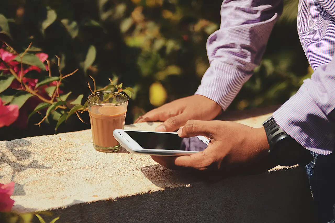 man using mobile phone in sunny garden