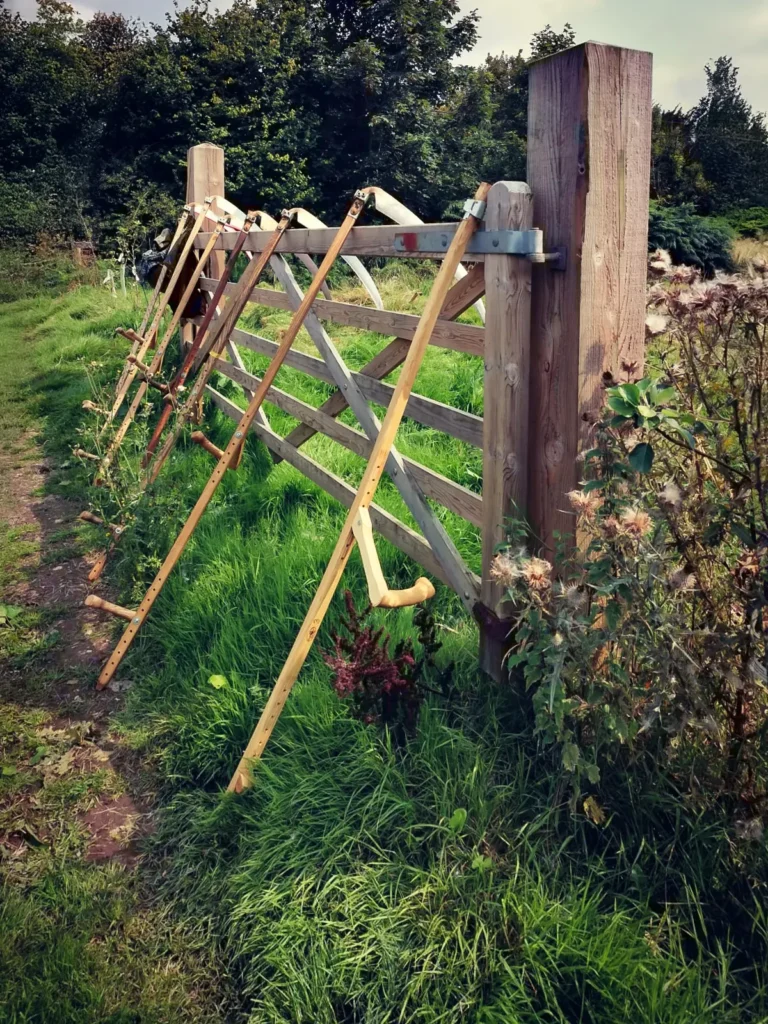 skyegrove 7 scythes leaning against a farm gate